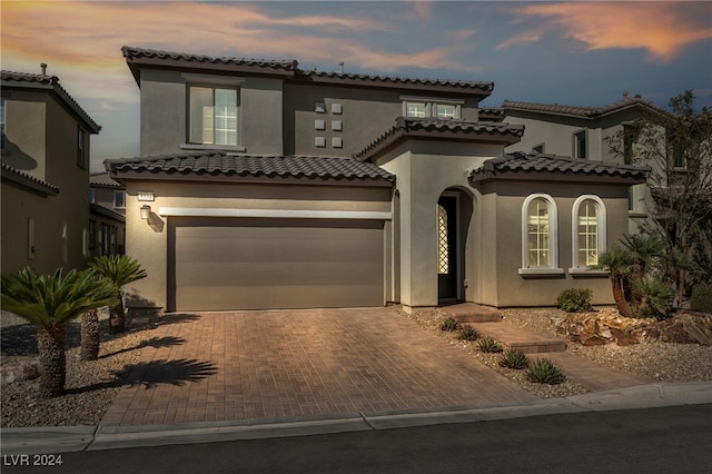 mediterranean / spanish home featuring a garage