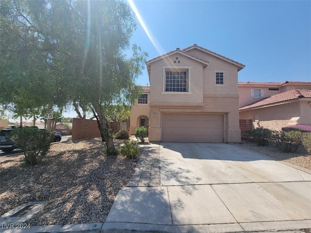 view of front of house with concrete driveway, a garage, stucco siding, and fence