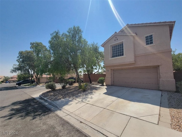 view of side of property featuring driveway, stucco siding, and an attached garage