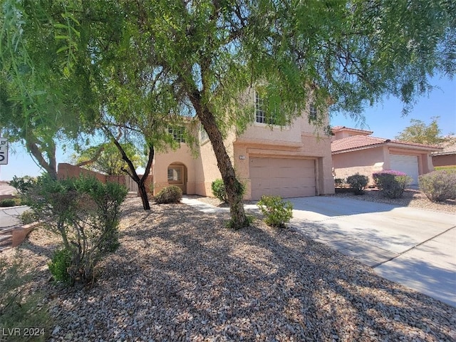 view of front of home with a tile roof, driveway, a garage, and stucco siding