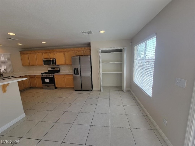 kitchen featuring stainless steel appliances, light tile patterned floors, and sink