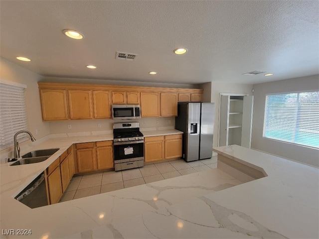 kitchen featuring a sink, visible vents, stainless steel appliances, light stone countertops, and recessed lighting