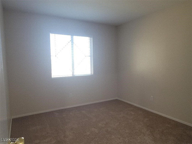 carpeted spare room featuring baseboards