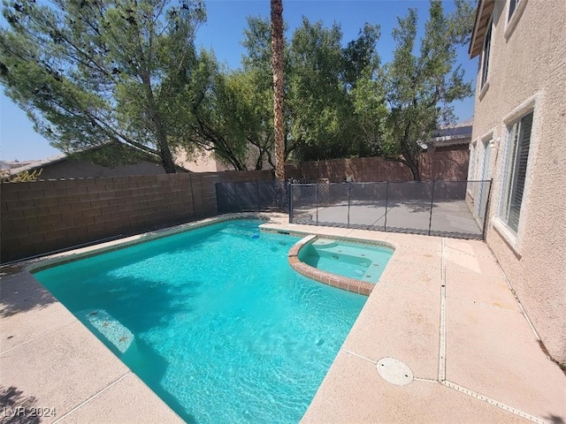 view of swimming pool with a patio, a fenced backyard, and a pool with connected hot tub