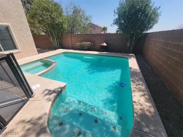 view of pool with a pool with connected hot tub and a fenced backyard