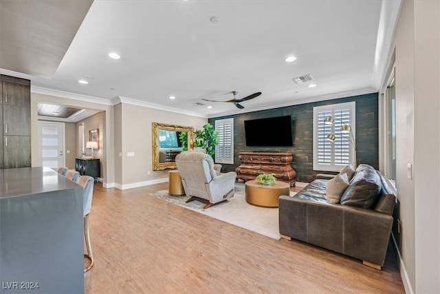 living room with ceiling fan, ornamental molding, and light hardwood / wood-style floors