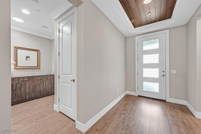 entryway featuring a wealth of natural light, a tray ceiling, and light hardwood / wood-style floors