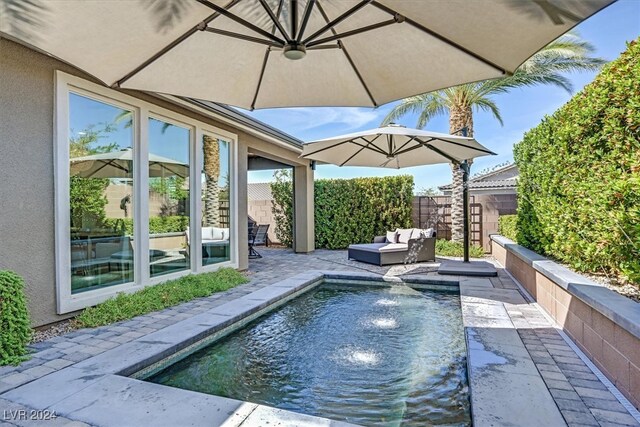 view of pool with a patio and pool water feature