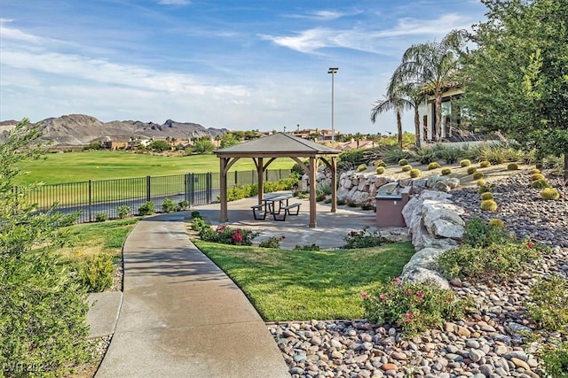 view of home's community with a lawn, a gazebo, a patio, and a mountain view