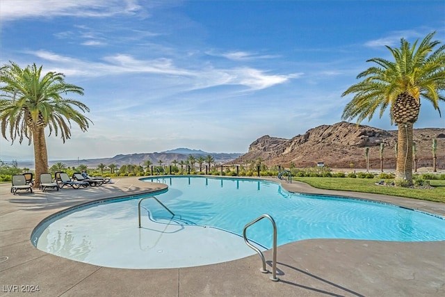 view of swimming pool with a mountain view and a patio