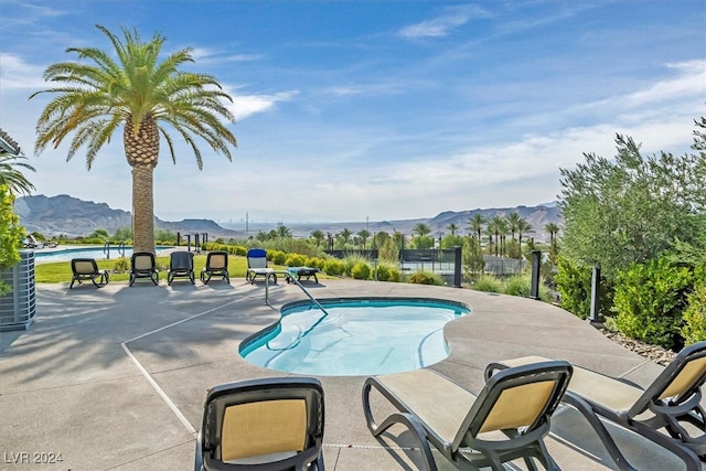 view of swimming pool featuring a patio and a mountain view