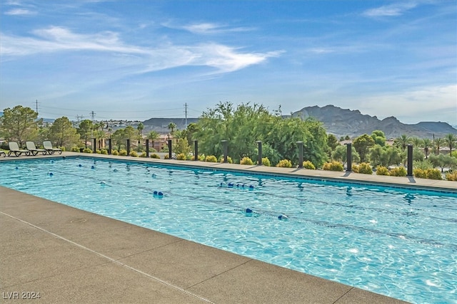 view of swimming pool with a mountain view