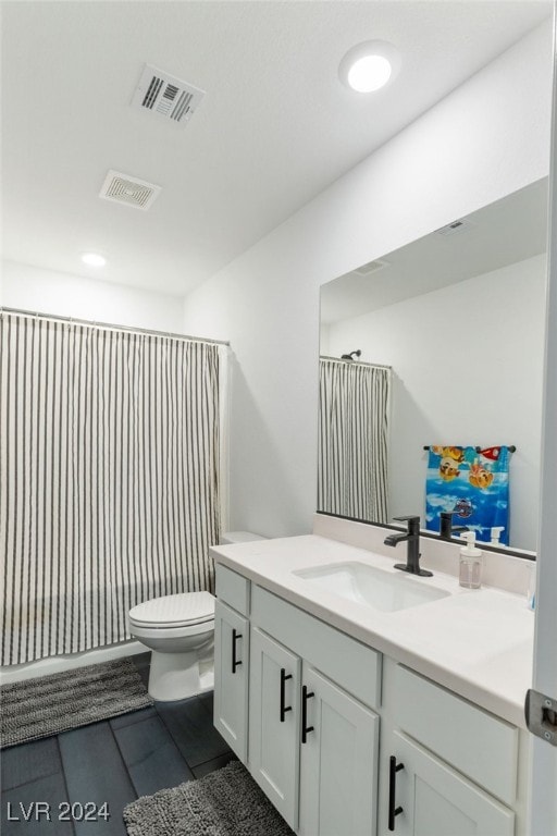 bathroom with tile patterned flooring, vanity, and toilet