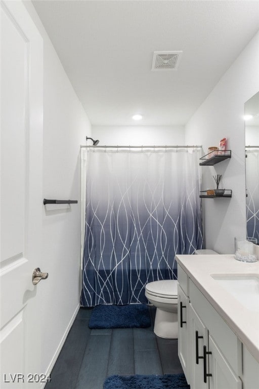 bathroom featuring curtained shower, vanity, and toilet