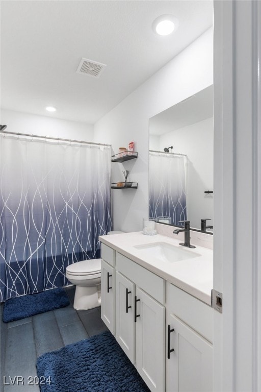 bathroom featuring walk in shower, vanity, and toilet