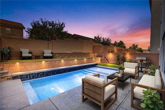 pool at dusk with a patio and outdoor lounge area