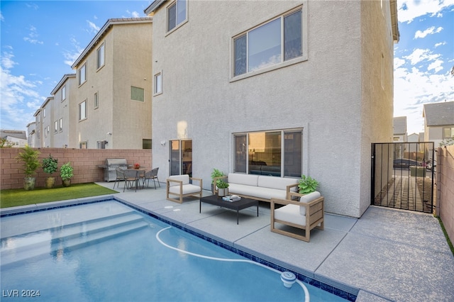 view of pool with area for grilling, an outdoor living space, and a patio area