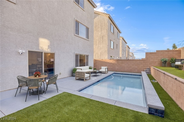 view of pool featuring a lawn, an outdoor living space, and a patio area