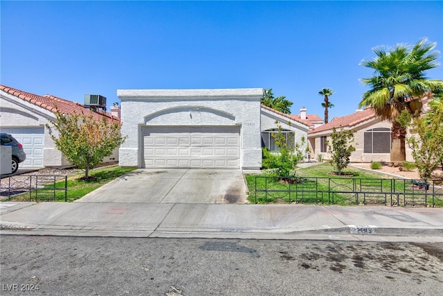 ranch-style house featuring a front yard, central air condition unit, and a garage