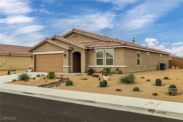 mediterranean / spanish-style home with central AC unit and a garage