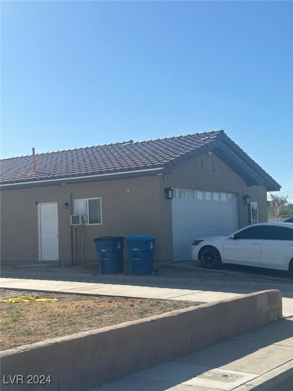 1840 Princeton St, North Las Vegas, NV 89030 - view of home's exterior featuring a tiled roof, a garage, and stucco siding