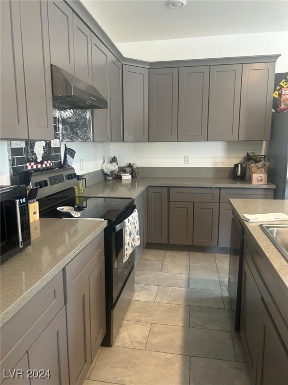 1840 Princeton St, North Las Vegas, NV 89030 - kitchen featuring electric range oven, under cabinet range hood, gray cabinetry, and light stone counters