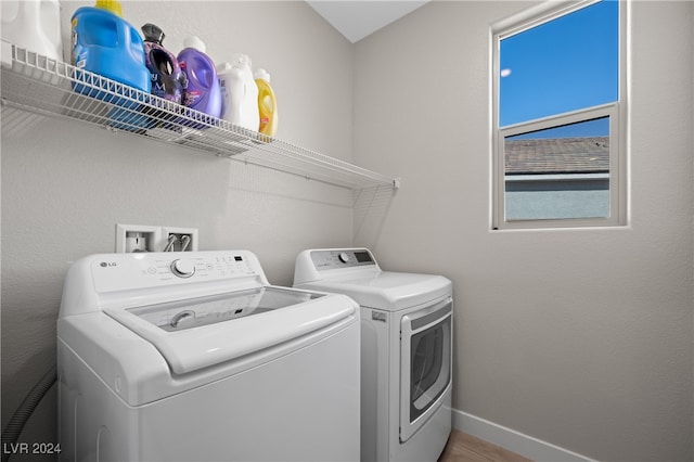 washroom with wood-type flooring and washing machine and dryer