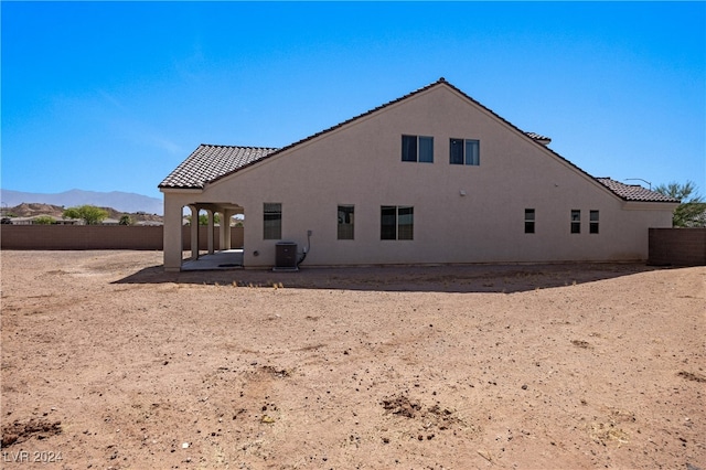 rear view of house featuring central AC unit, a mountain view, and a patio area