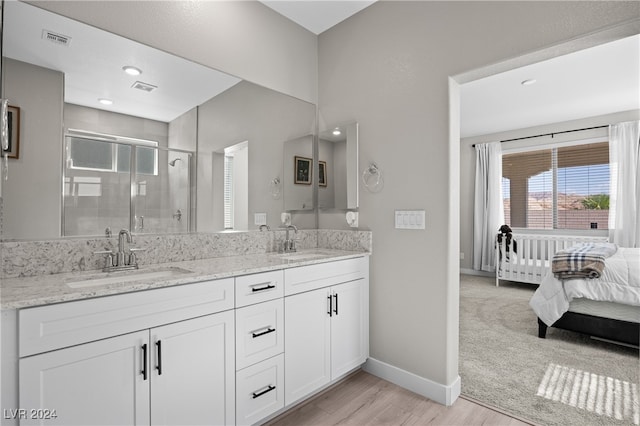 bathroom featuring wood-type flooring, a shower with door, and vanity