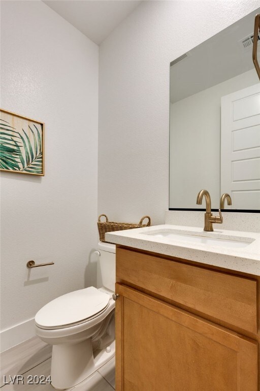 bathroom with tile patterned floors, vanity, and toilet