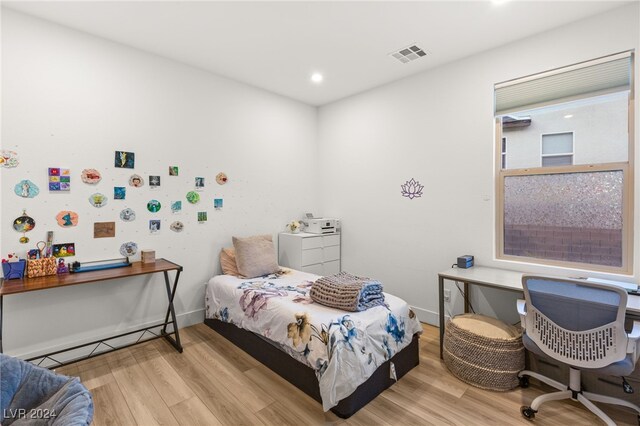 bedroom featuring washer / clothes dryer, a baseboard radiator, and light hardwood / wood-style flooring