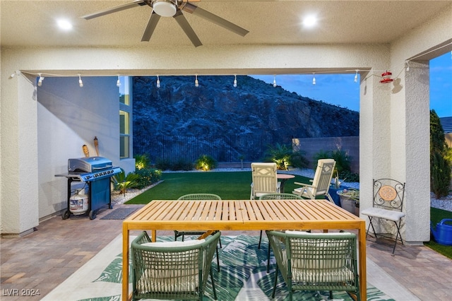 view of patio / terrace with ceiling fan, a mountain view, and a grill