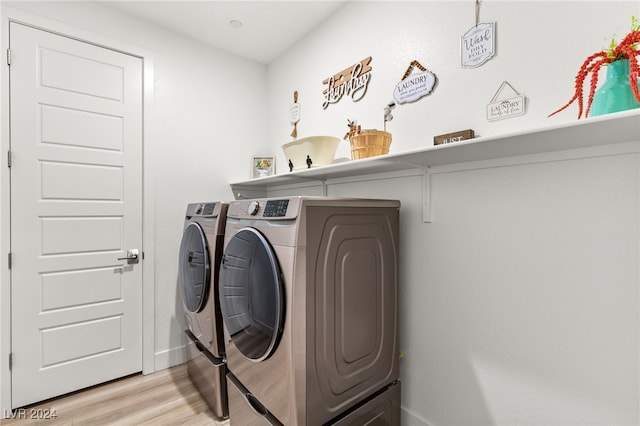 laundry area featuring separate washer and dryer and light hardwood / wood-style floors