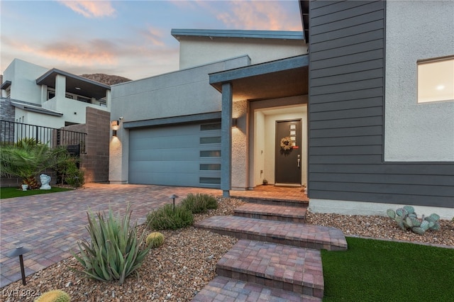 exterior entry at dusk with a garage