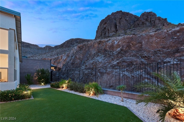 yard at dusk featuring a mountain view