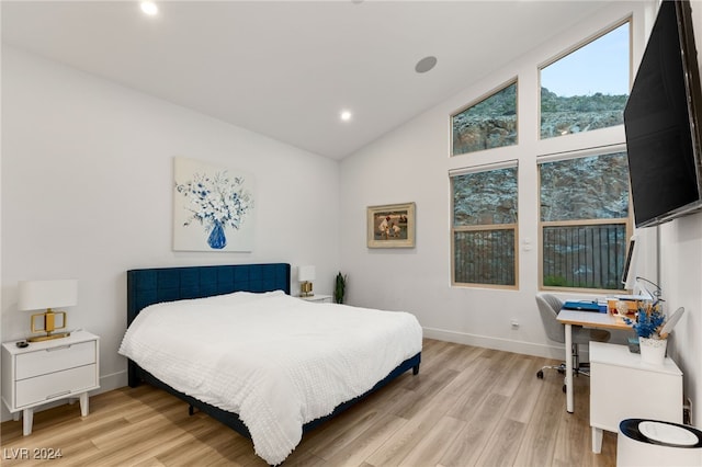 bedroom featuring high vaulted ceiling and light wood-type flooring