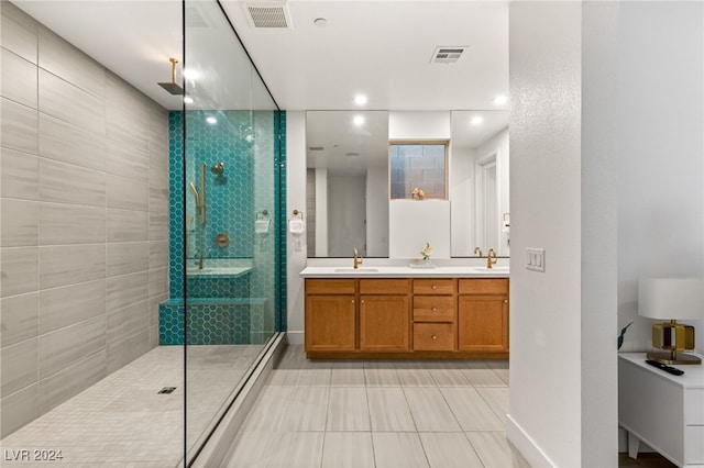 bathroom with tiled shower, vanity, and tile patterned flooring