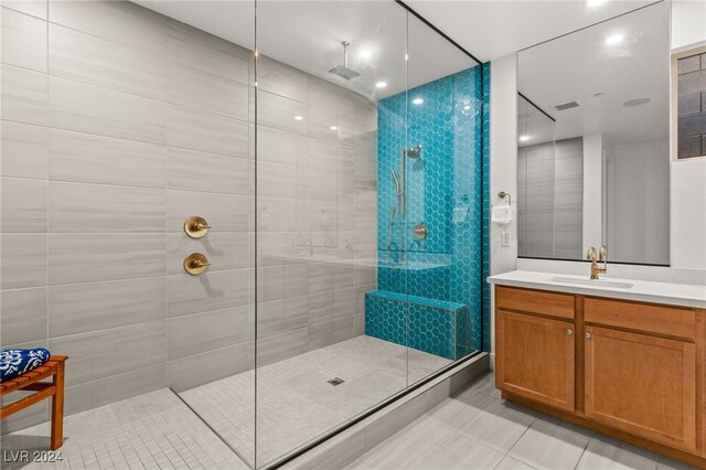 bathroom featuring vanity, a tile shower, and tile patterned floors