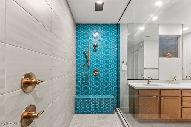 bathroom with vanity, tile walls, tile patterned floors, and tiled shower