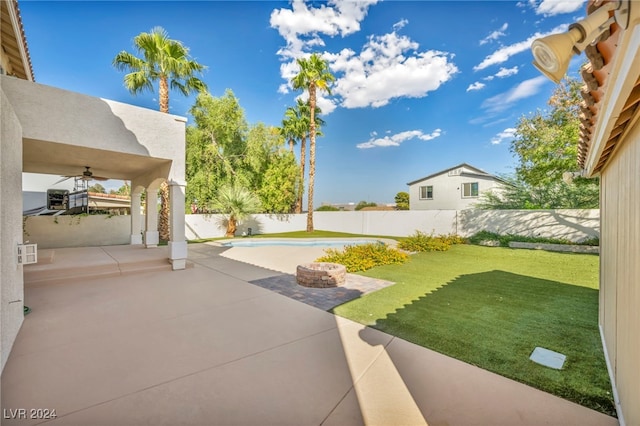 view of yard with a fenced in pool, a patio, and ceiling fan