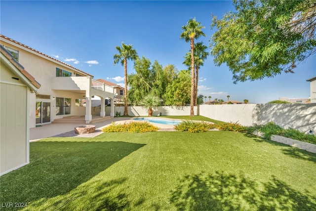 view of yard featuring a fenced in pool, a balcony, and a patio area