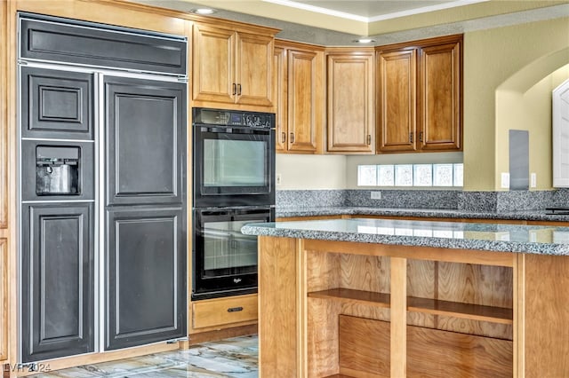 kitchen featuring double oven, ornamental molding, and stone counters