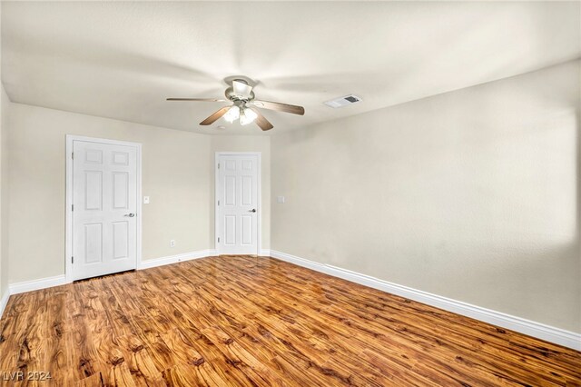 empty room with hardwood / wood-style flooring and ceiling fan