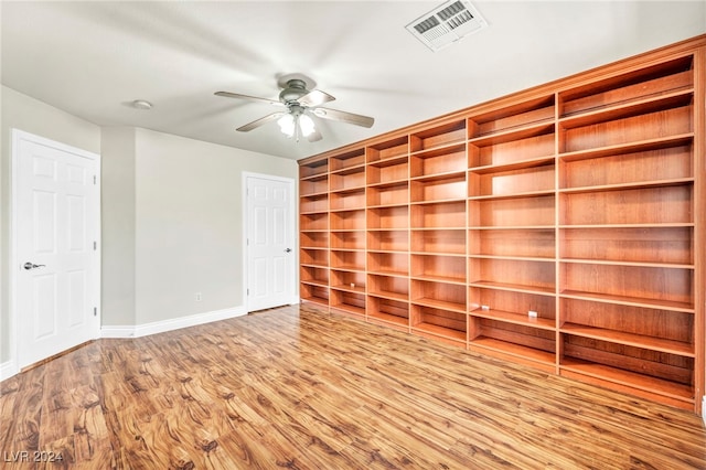 unfurnished room with ceiling fan, built in features, and light wood-type flooring