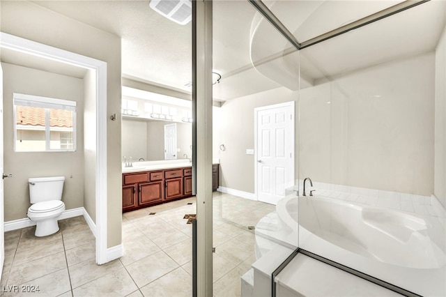 bathroom with tile patterned flooring, vanity, a washtub, and toilet