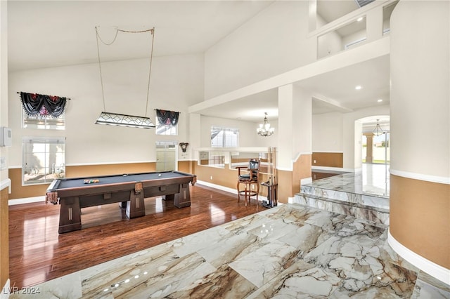 game room with high vaulted ceiling, hardwood / wood-style flooring, billiards, and a chandelier