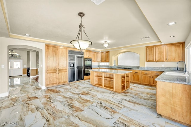 kitchen with sink, decorative light fixtures, gas cooktop, a raised ceiling, and a kitchen island