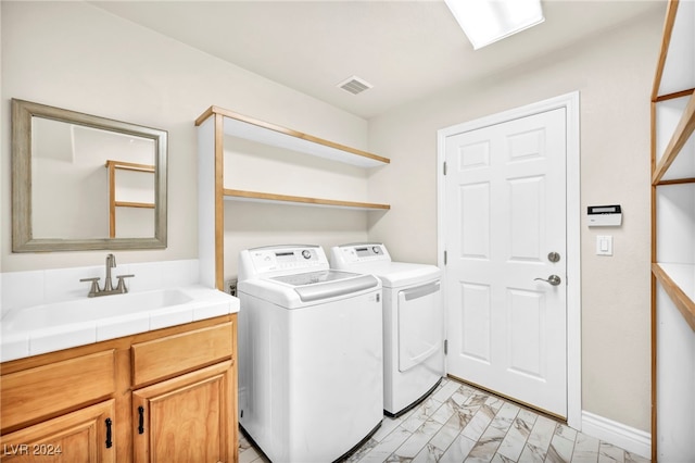 washroom with separate washer and dryer, sink, and cabinets