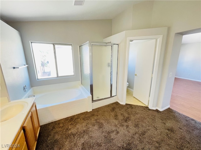 full bathroom with separate shower and tub, vanity, vaulted ceiling, and toilet