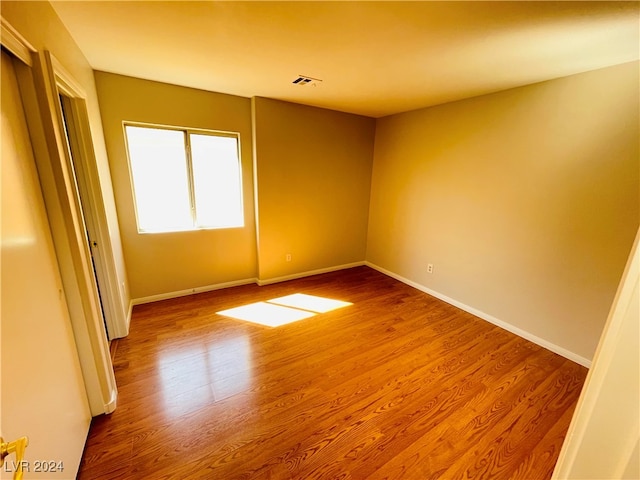 unfurnished room with wood-type flooring